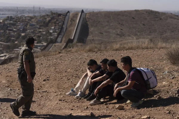 A Border Patrol agent with four detained men caught crossing the border illegally. Photo by AP Photo / Gregory Bull.